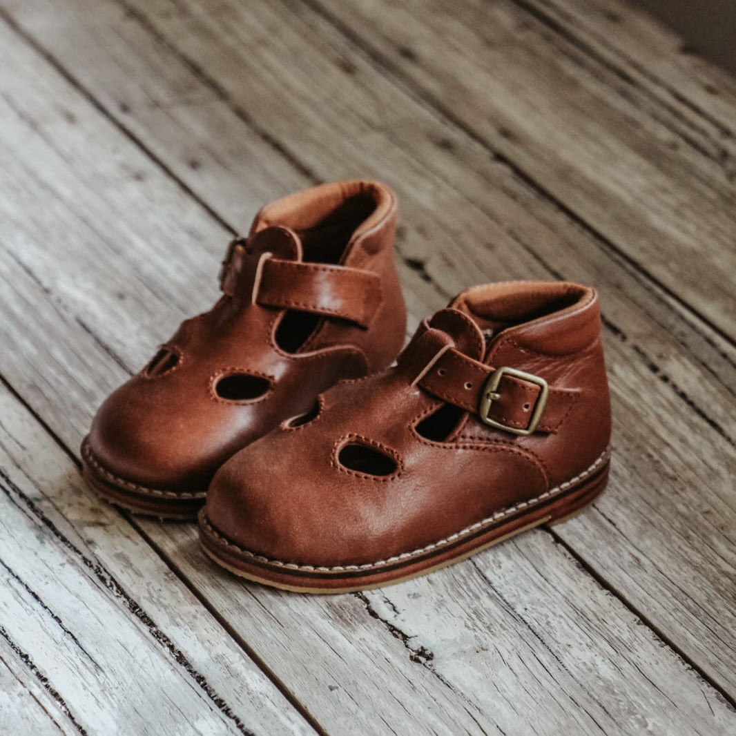 Pair of brown leather shoes on a wooden floor