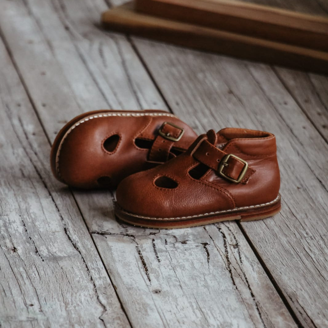 Pair of brown leather shoes on a wooden floor
