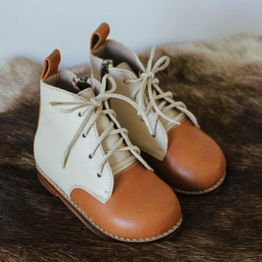 Pair of tan and brown leather boots on a fur surface