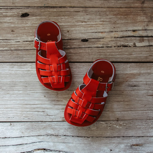Red sandals on a wooden surface